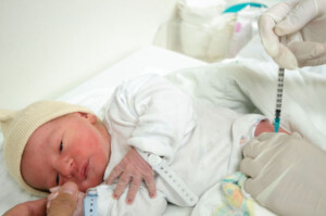 A one day old baby boy having his first injection